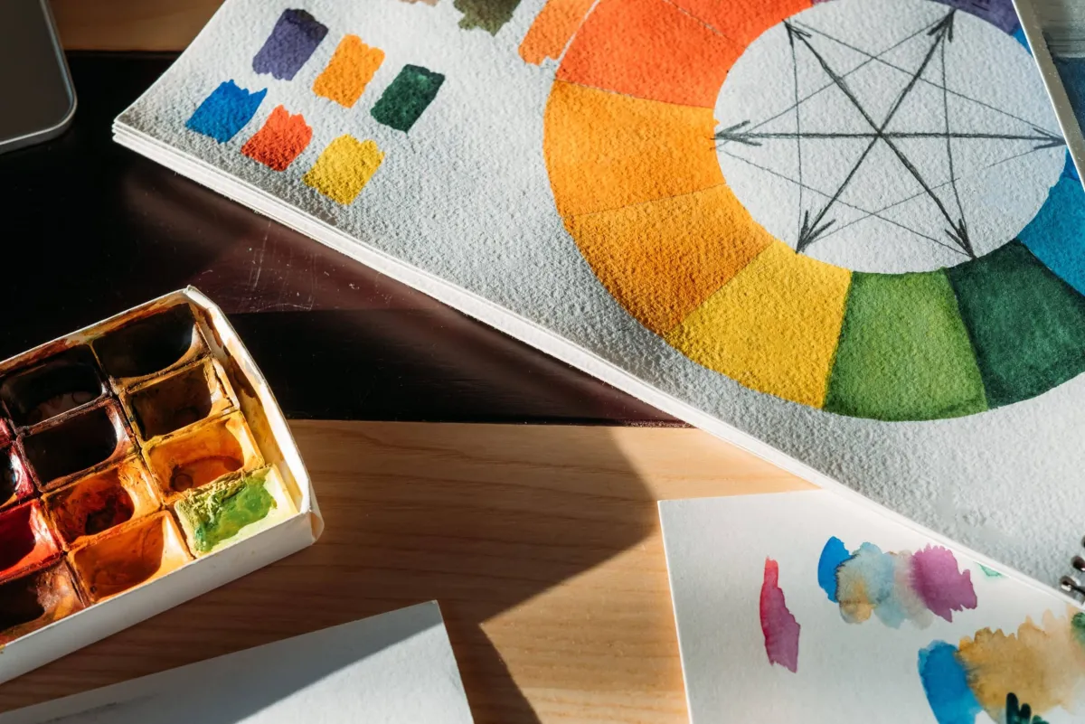Imagem ilustrativa representando a teoria das cores. A capa apresenta um círculo cromático vibrante, destacando as cores primárias, secundárias e terciárias. O design transmite a importância das cores no design e sua influência na percepção visual.